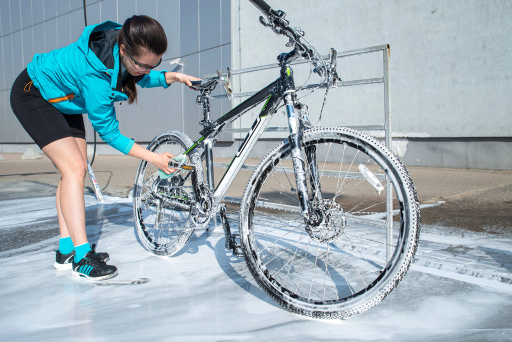 Cyclist cleaning bike