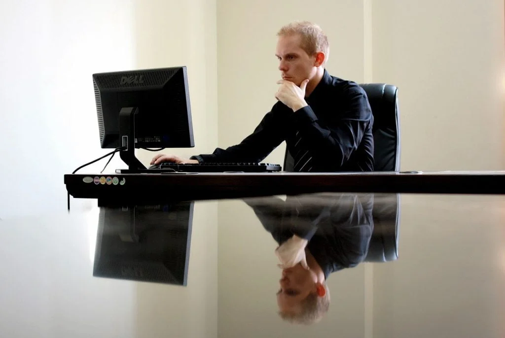 man looks puzzled at computer monitor